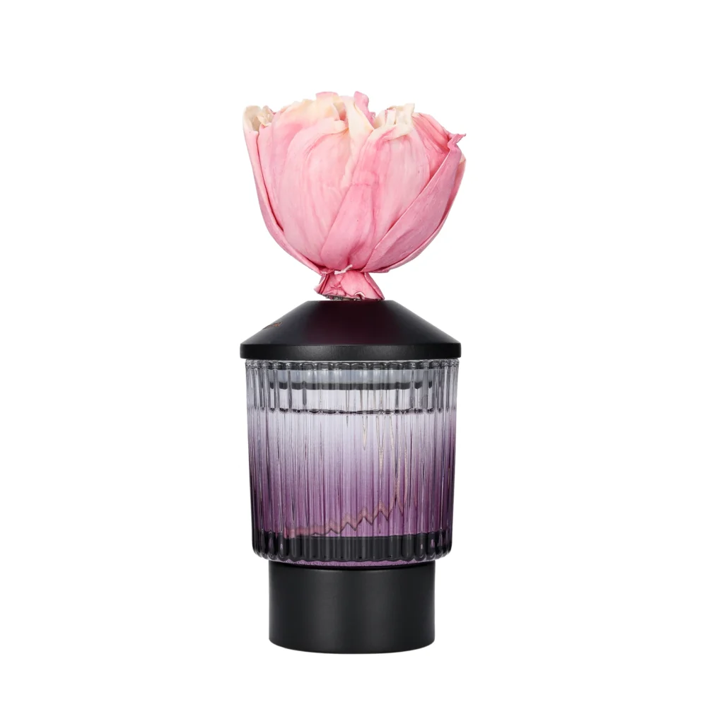 Fluted plum-tinted glass diffuser with a black lid and pink sola wood flower topper